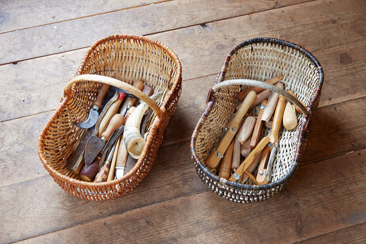 Handwoven willow baskets holding basket-making tools on a wooden floor / 木の床に置かれた、道具が収められたやなぎの手編みかご