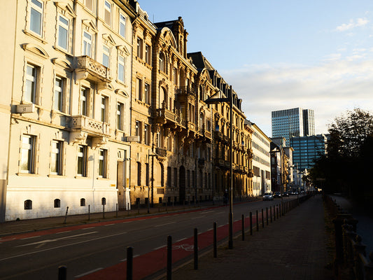 Golden morning light illuminating historic buildings in Frankfurt, with a wide bicycle lane along the street / 早朝の光に照らされるフランクフルトの歴史的建物と、通りに整備された広い自転車レーン