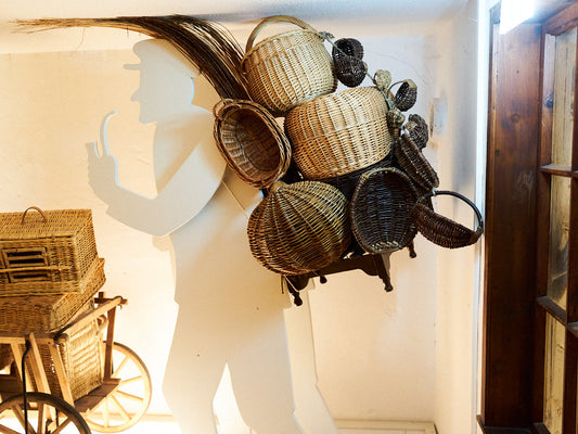 Basket display mounted on a wall silhouette of a peddler carrying baskets, Dalhausen Basketmakers’ Museum 行商人のシルエット壁面に複数のかごが取り付けられた展示、ダルハウゼンかご職人博物館