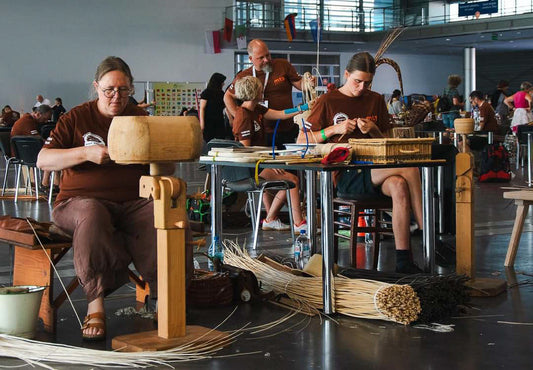 Basket makers working at tables during the World Wicker and Weaving Festival in Poland / ポーランドの世界かご編み大会で、テーブルに向かい制作に取り組む編み手たち