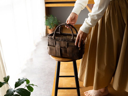 Placing a walnut bark basket bag on a stool by the window / 窓辺でスツールの上にくるみ樹皮のかごバッグを置いている様子