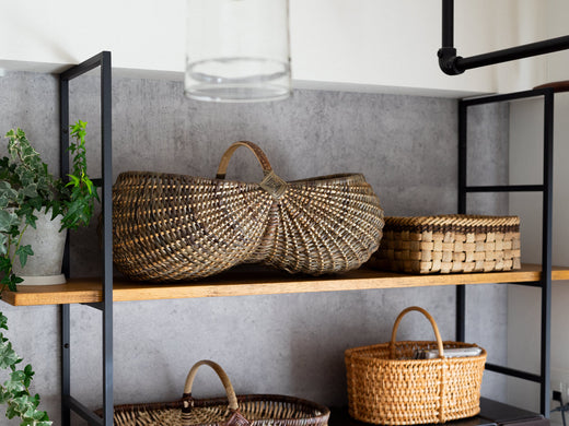 Handwoven willow baskets displayed on wooden shelves in the shop / 店内の木製棚に並ぶ、やなぎの手編みかご