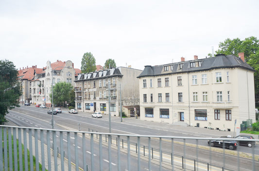 Poznań city street seen from near the dormitory, early morning light, tram tracks and historic apartment buildings / ポーランド・ポズナン市、ドミトリー近くから望む街並み、早朝の光の中に走るトラムの線路と歴史ある集合住宅