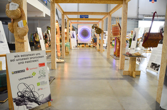 German exhibition area with wooden frames and basketry works at the World Wicker and Weaving Festival 2023 in Poland / 世界かご編み大会2023（ポーランド）におけるドイツチームの展示で、木組みのフレーム内にかご作品が並ぶ会場風景