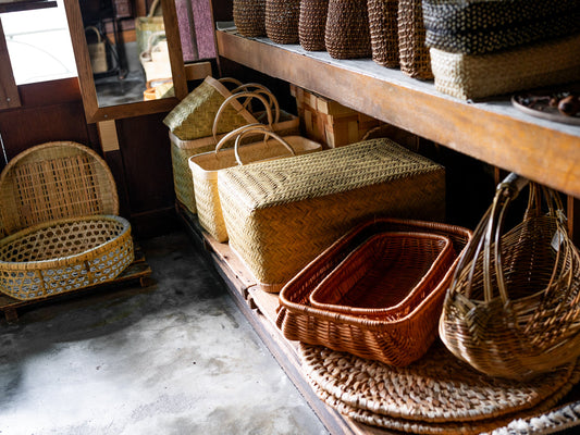 Baskets arranged on wooden shelves inside the shop / 店内の木棚に並べられたさまざまなかごの様子