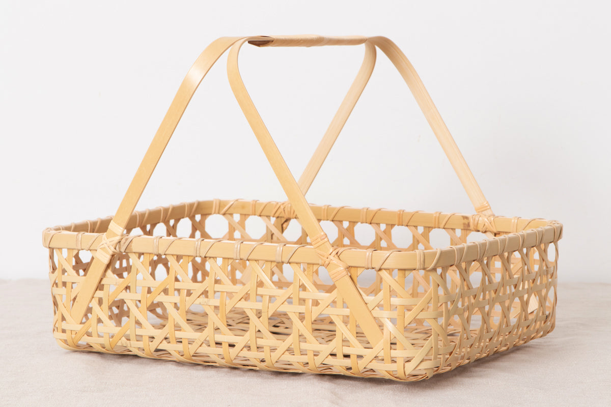 Rectangular white bamboo basket with handles on a surface / 白竹の手つき角バスケットを置いた様子