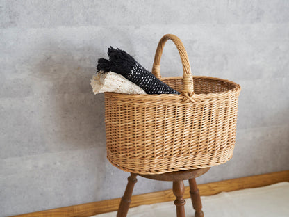 Picnic basket XL with willow weave holding two folded stoles on a stool / リトアニアやなぎのピクニックバスケットXLにストールを入れた様子