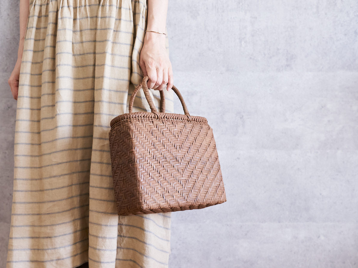 Feather-pattern grapevine basket bag being held / やまぶどうの手提げを持っている様子