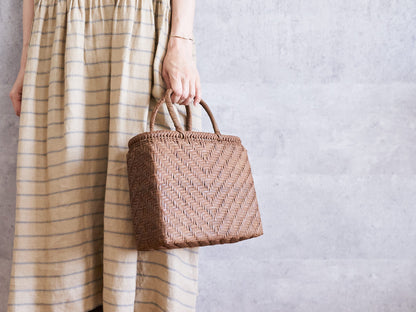Feather-pattern grapevine basket bag being held / やまぶどうの手提げを持っている様子