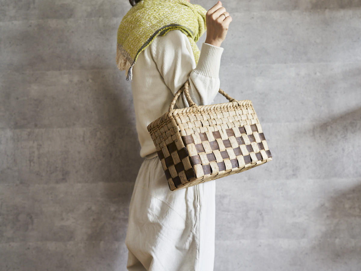 Walnut bark checker handbag with under-check pattern held on the arm / くるみの表皮市松編み手提げ（アンダーチェック）を腕に掛けた様子