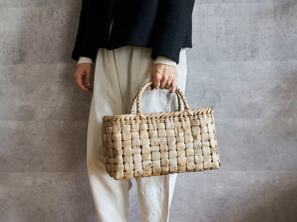 Walnut bark wide checker handbag held in hand / くるみの総表皮市松編みのワイド手提げを手に持った様子