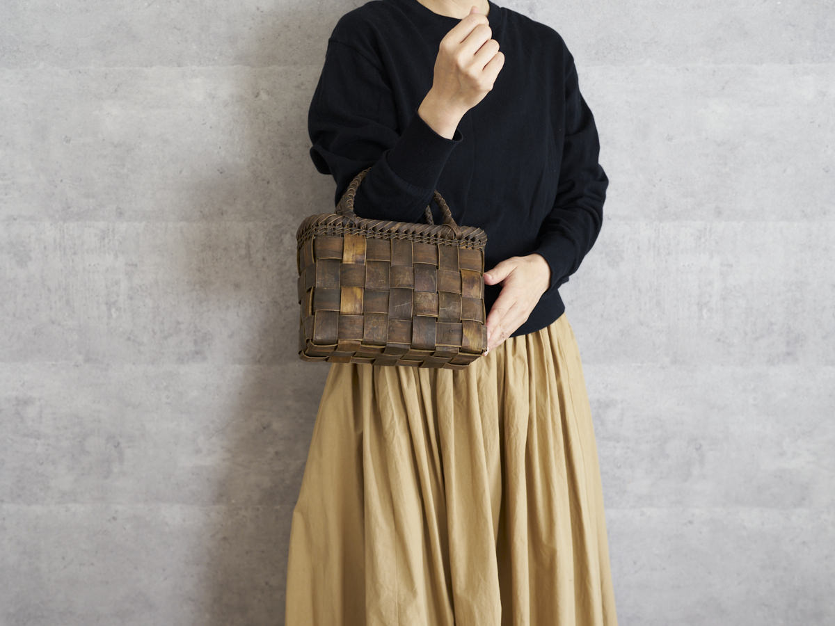 Walnut bark mini checker handbag held on the arm / くるみの総裏皮市松編みミニ手提げを腕に掛けた様子