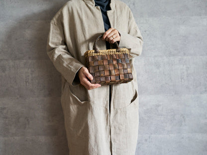 Walnut bark tiny checker handbag held in hand / くるみのtinyサイズ・裏皮市松編み手提げ（縁表皮）を手に持った様子