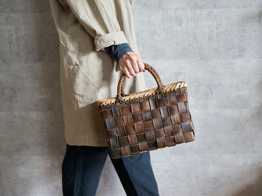 Walnut bark handbag with checker weave held in hand / くるみの裏皮市松編み手提げ（縁表皮）を手に持った様子