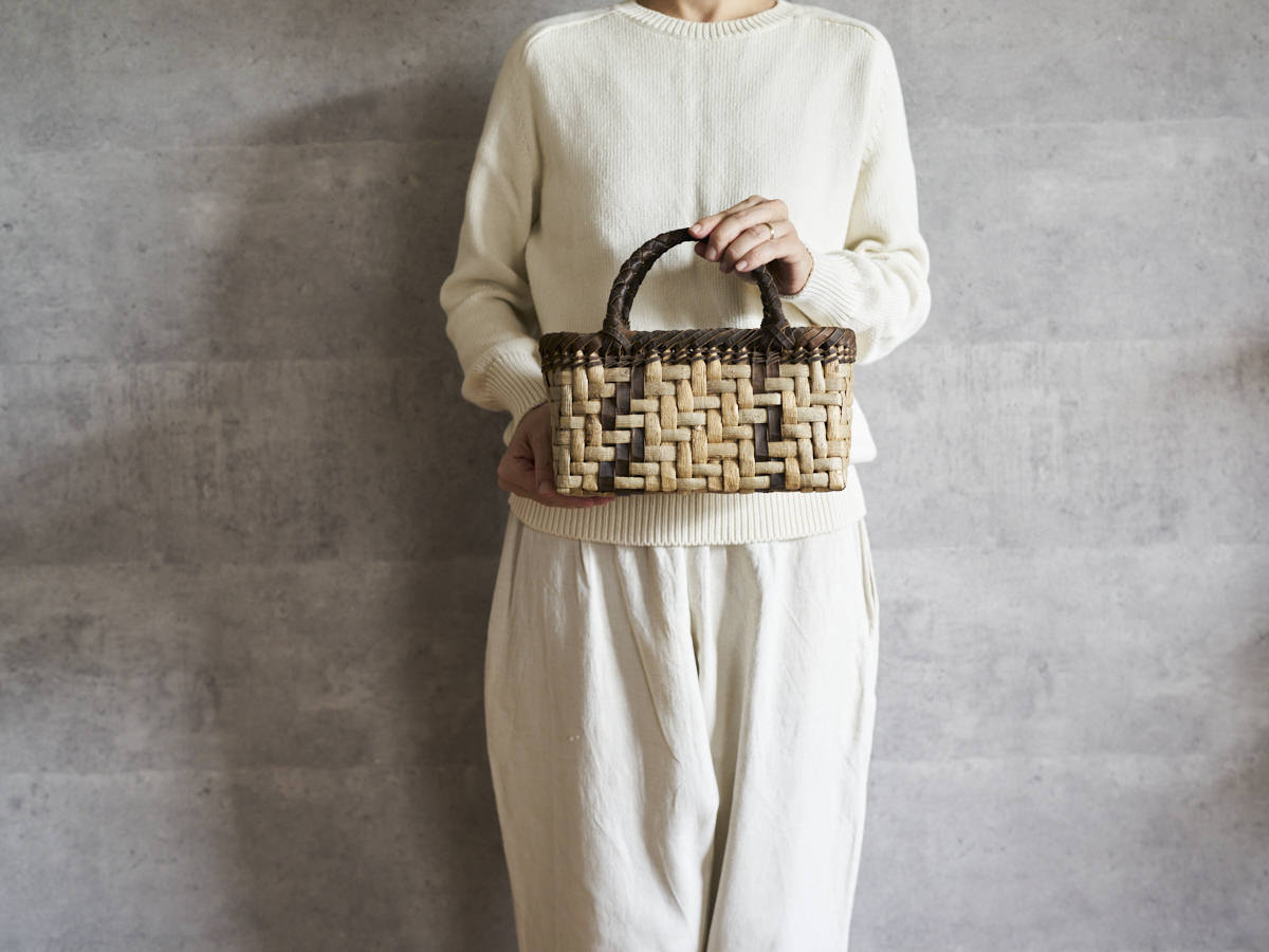 Walnut bark handbag with lightning weave held in hand / くるみの表皮あじろ編み手提げ（ライトニング模様）を手に持った様子