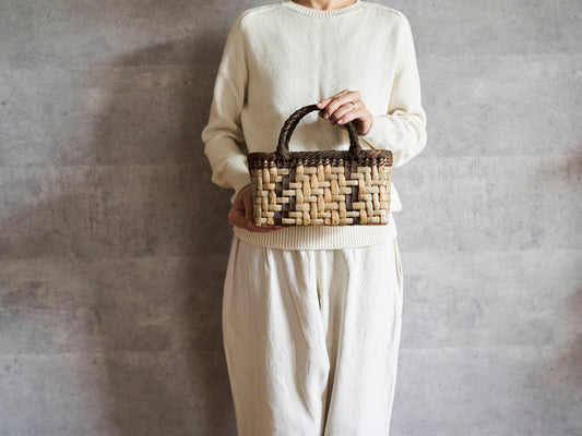 Walnut bark handbag with lightning weave held in hand / くるみの表皮あじろ編み手提げ（ライトニング模様）を手に持った様子