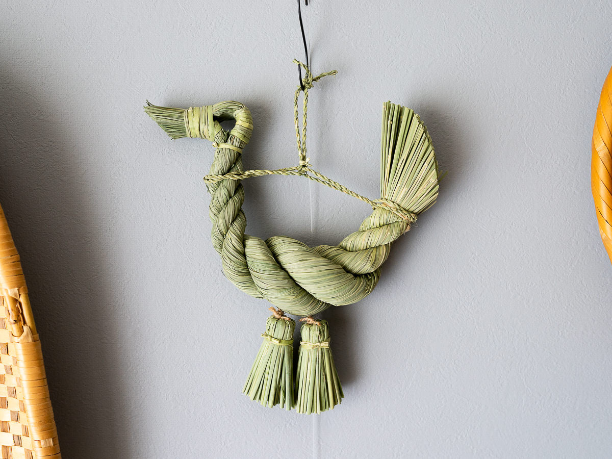 Rice straw shimekazari shaped like a rooster on a wall / 稲わらのしめかざり（寿酉）が壁に掛けられている様子