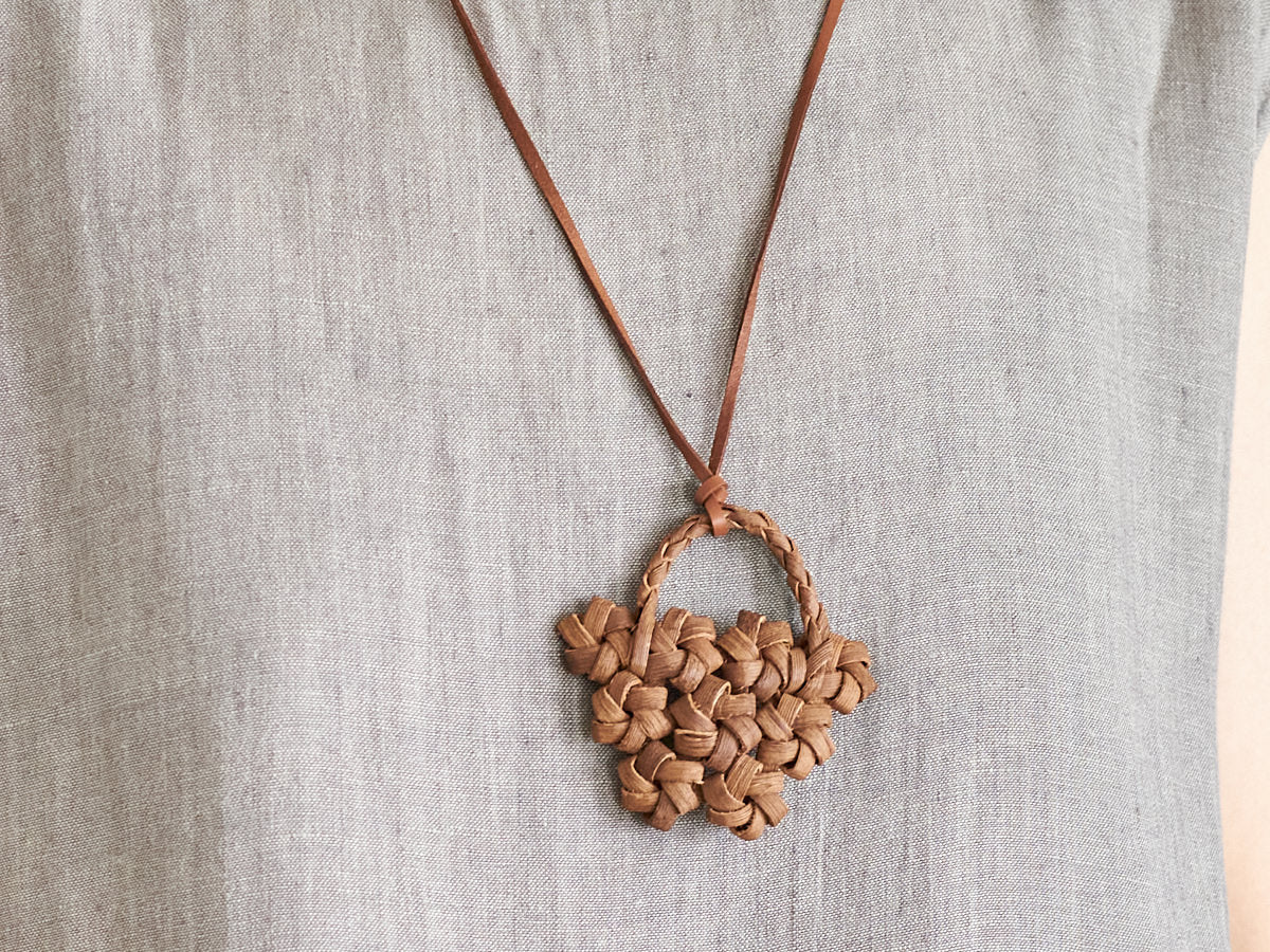 Wild grape vine flower basket pendant worn around the neck / 山ぶどうの花かごペンダントを首に掛けた様子