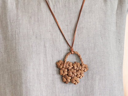 Wild grape vine flower basket pendant worn around the neck / 山ぶどうの花かごペンダントを首に掛けた様子