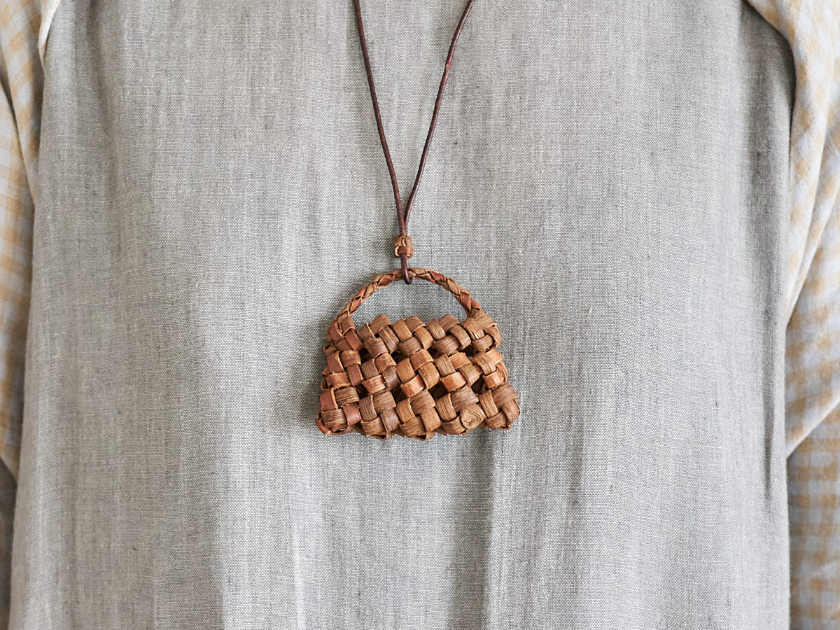 Wild grape vine basket pendant worn around the neck / 山ぶどうのかごペンダントを首に掛けた様子