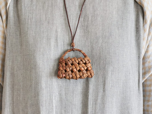 Wild grape vine basket pendant worn around the neck / 山ぶどうのかごペンダントを首に掛けた様子