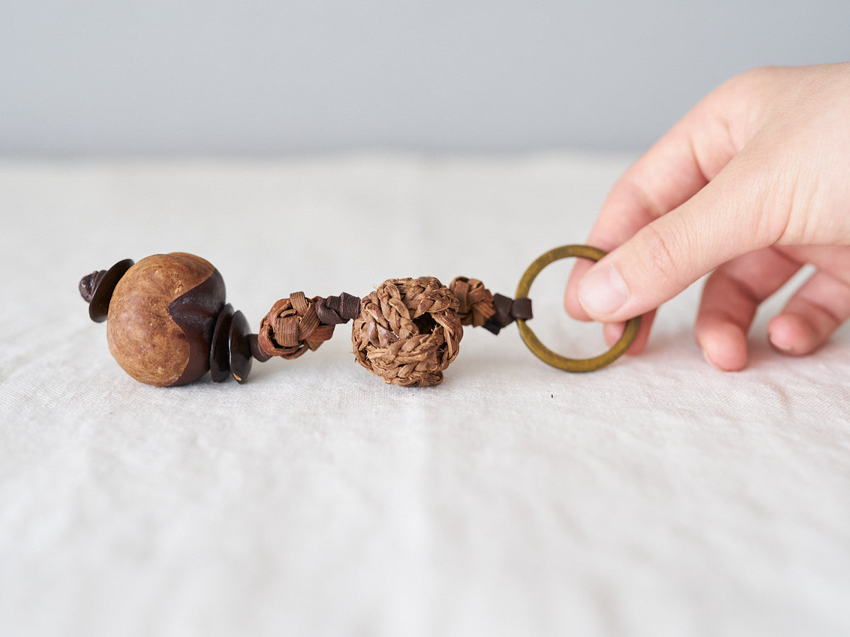 Wild grape vine and horse chestnut key holders held in the hand / 山ぶどうと栃の実のキーホルダーを手に持った様子