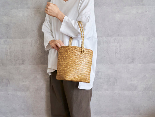 One-handle bucket basket made of krajood grass being carried / カチューのワンハンドルバケツ型手提げを持っている様子