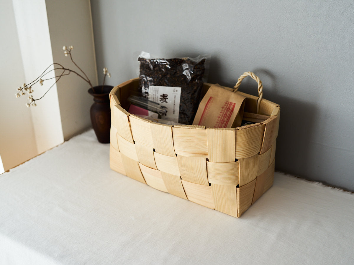 A pine wall basket with double-ring handles holding groceries placed on the floor / 食材を入れたパインのダブルリング付きウォールバスケットを床に置いた様子