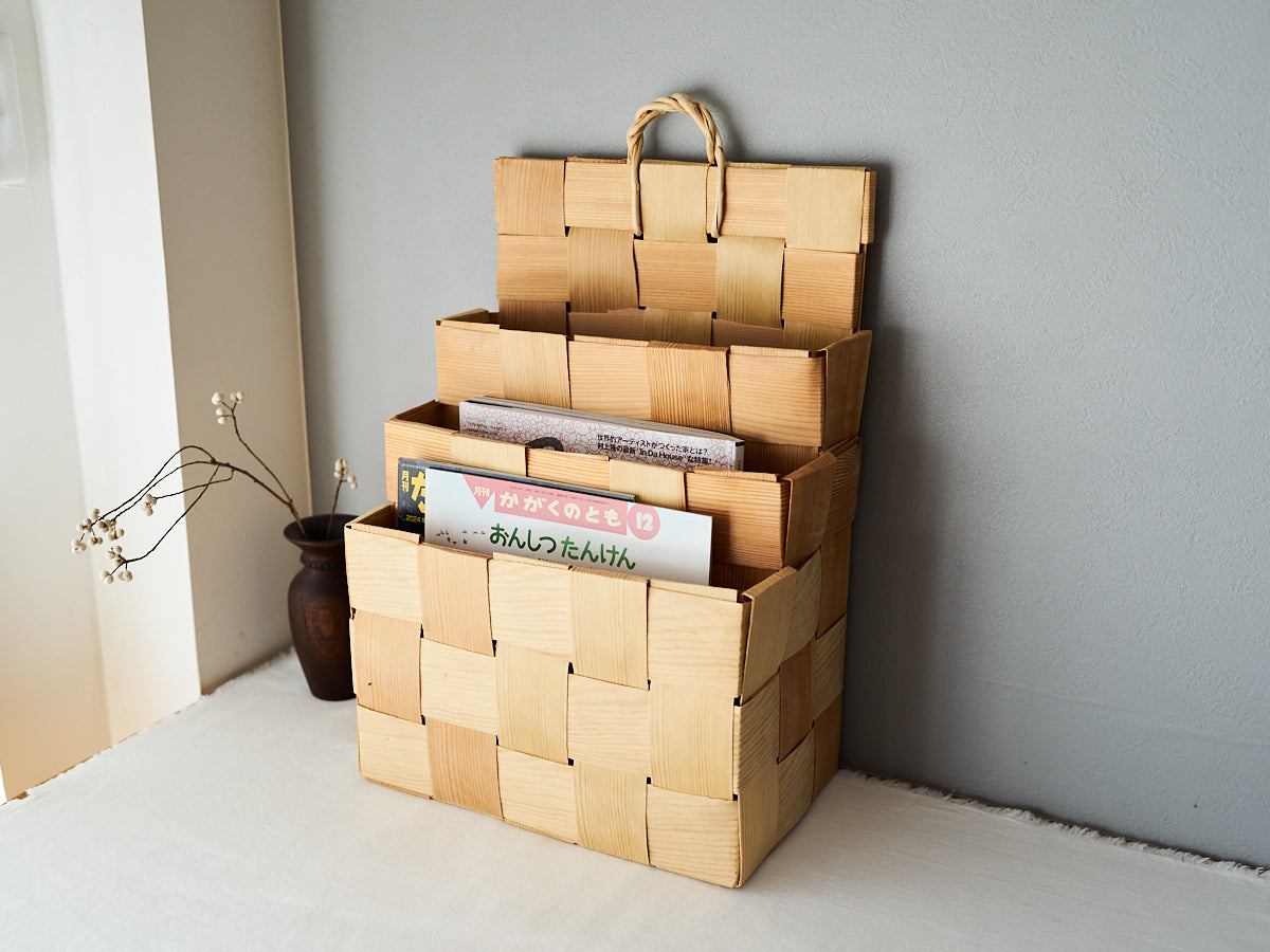 Pine magazine racks in three sizes placed against the wall holding magazines / 壁に立てかけたパインのマガジンラックに雑誌を入れた様子