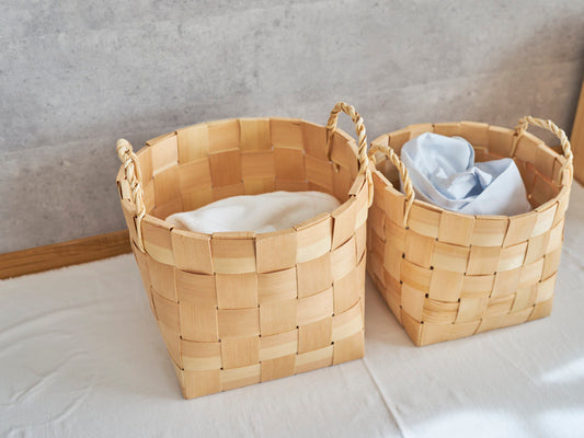 Tall pine laundry baskets with handles holding folded laundry placed side by side / 洗濯物を入れたパインのトール型ランドリーバスケットを並べた様子
