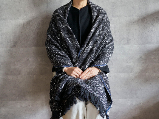 Gara-bou spun cotton black herringbone stole draped over shoulders / ガラ紡コットンの黒のヘリンボーン柄ストールを肩に羽織った様子