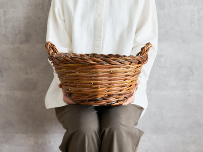 Round willow basket with two handles, handwoven texture visible / 両手つきのやなぎの丸かご、編み目が見える様子